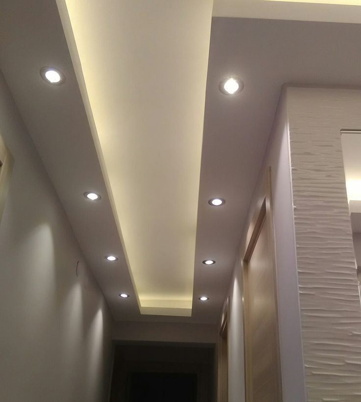 Teto iluminado em corredor com forro drywall e luminárias embutidas